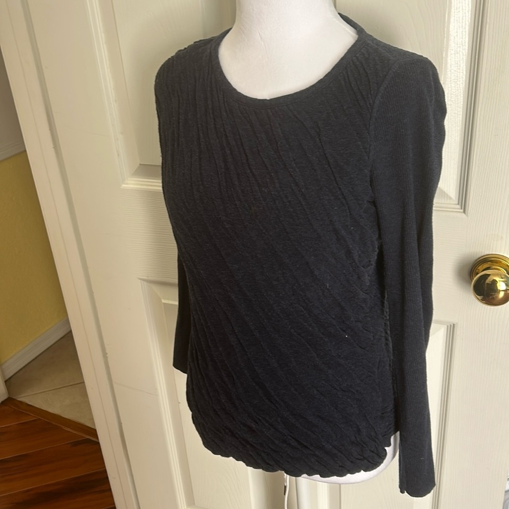 Blue sweater with diagonal cut on bottom.
